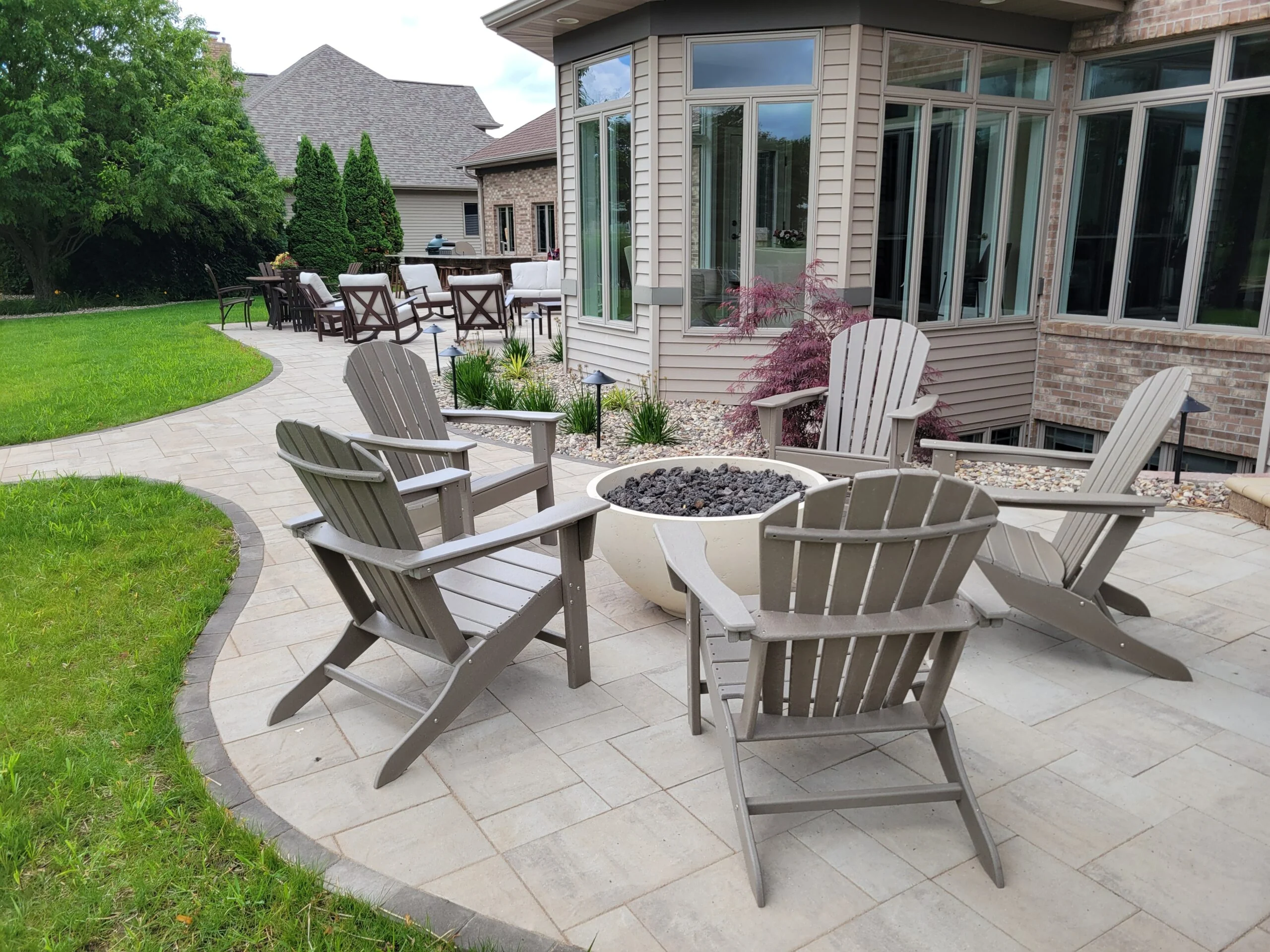 Earthscape curved paver patio with Adirondack seating and an outdoor gathering area