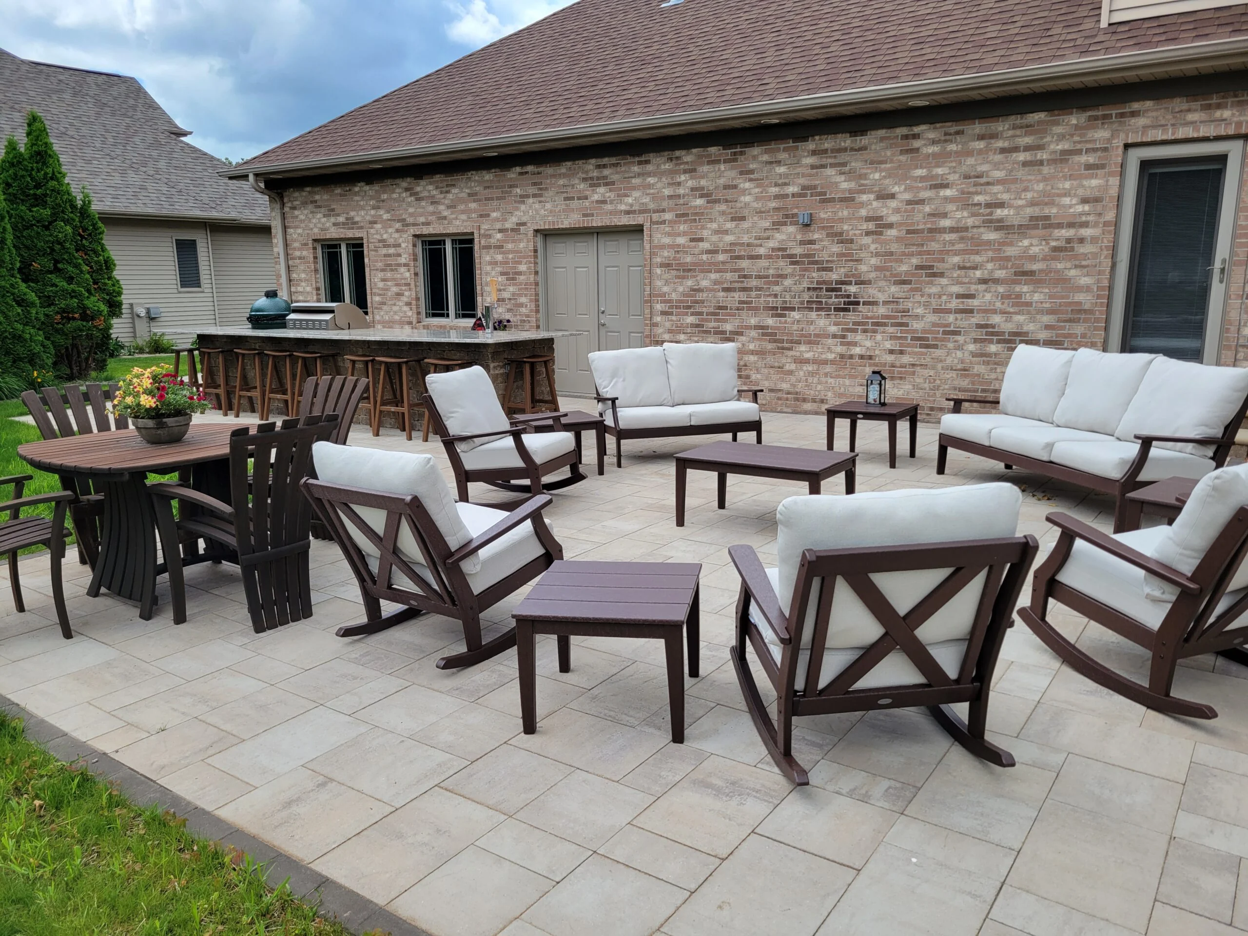 Finished Earthscape paver patio with lounge seating, dining space, and an outdoor kitchen