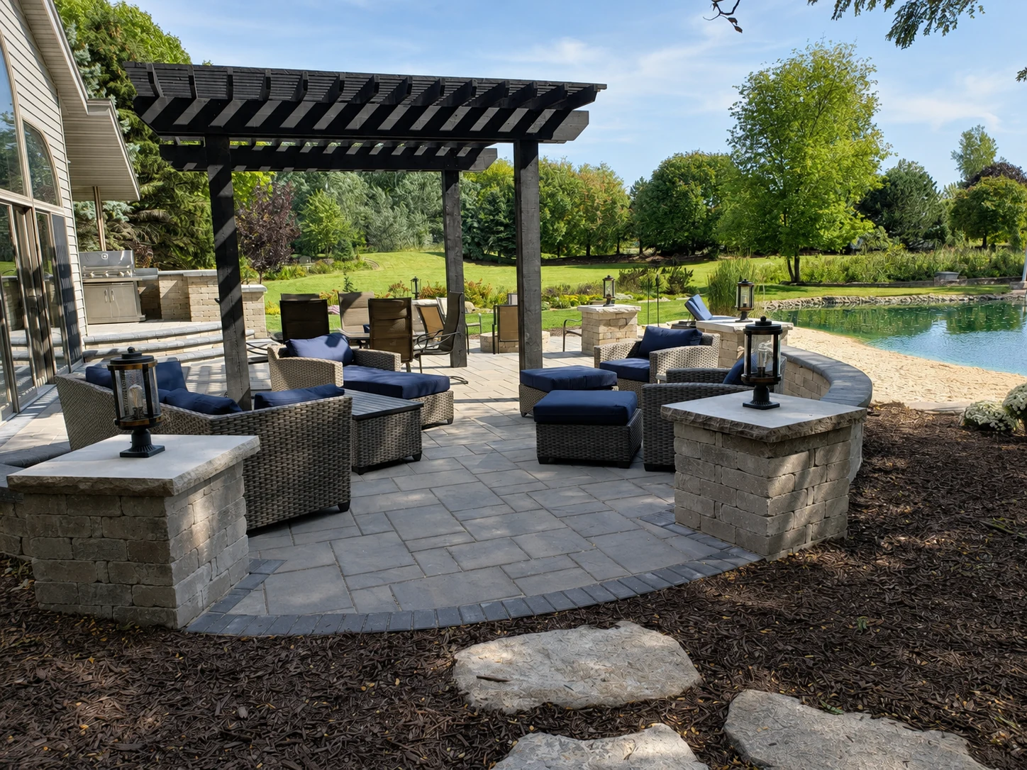An Earthscape outdoor living space beside a pond
