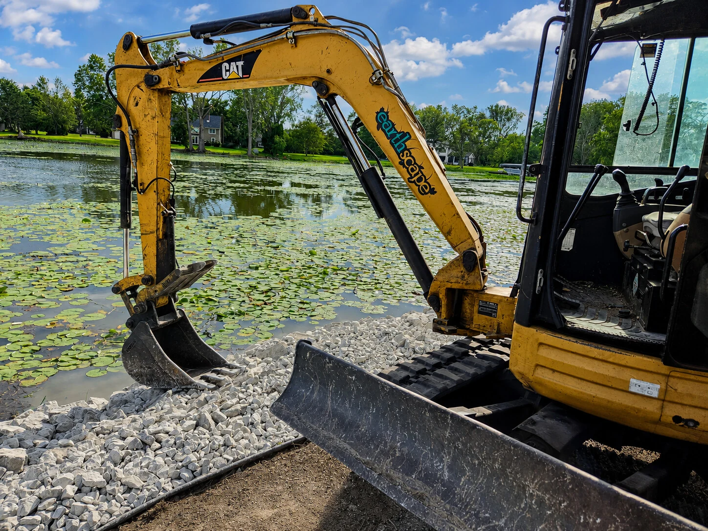 Earthscape excavator placing riprap stone along the water