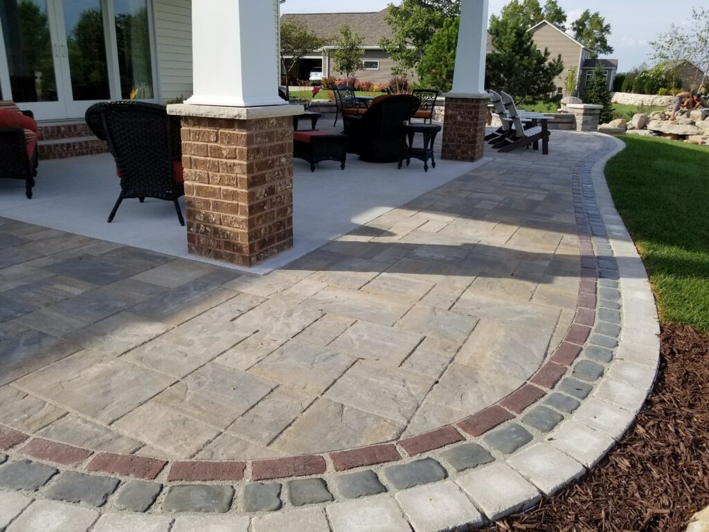 Multitone paver patio with brick columns and a curved border.