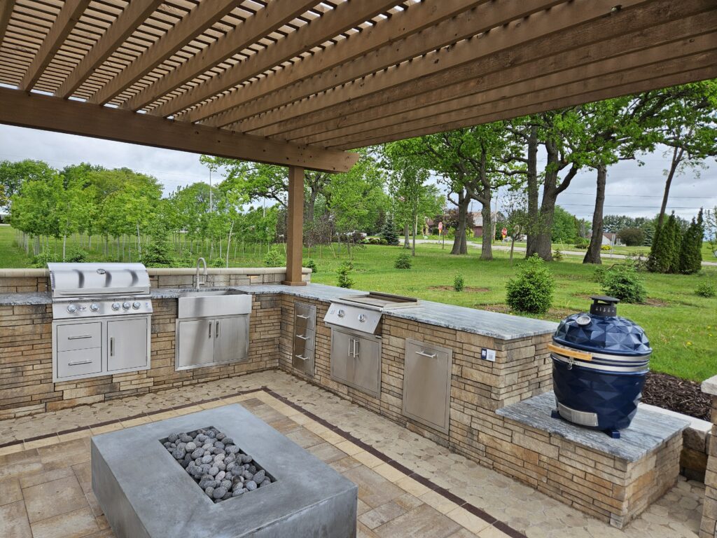 Cedar pergola shades a stone outdoor kitchen and fire table.