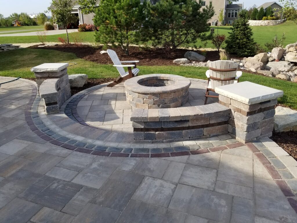 Round fire pit with integrated seating walls and decorative paver bands.