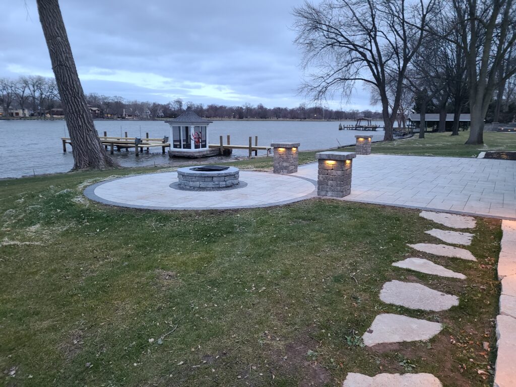 Circular paver fire-pit terrace overlooking a lake.