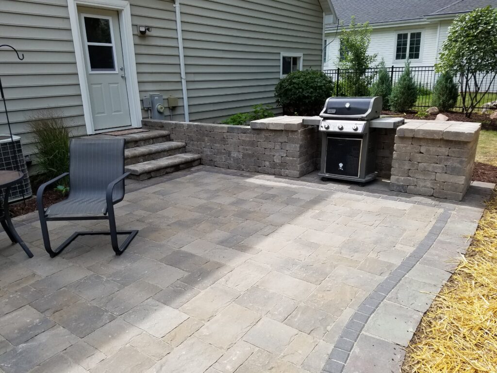 Paver patio with built-in grill station, steps, and seating.