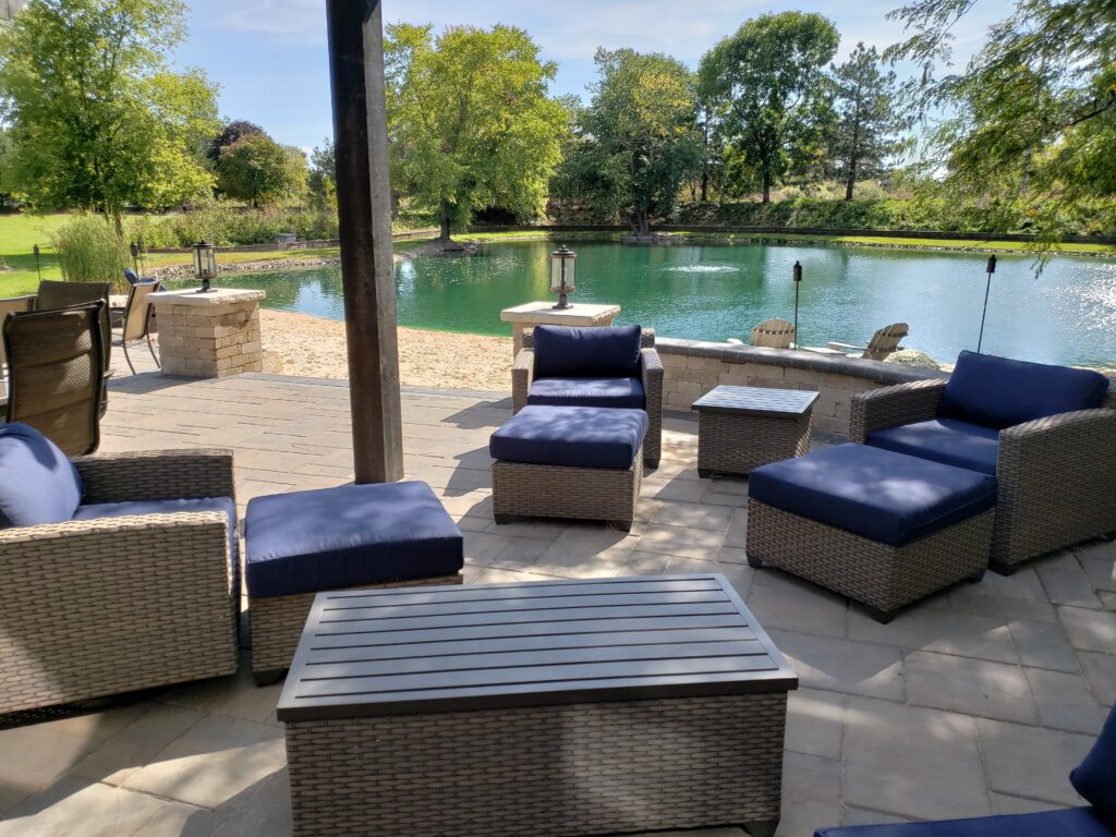 Cushioned lounge seating arranged on a paver patio beside the pool.